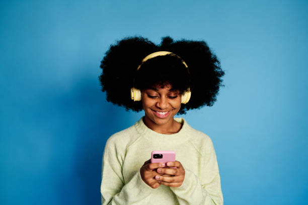 istock Cheerful black woman using smartphone 1457469478