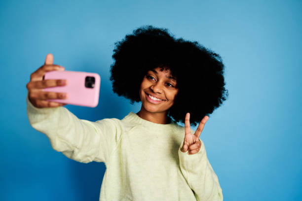 istock Cheerful black woman taking selfie 1457470375