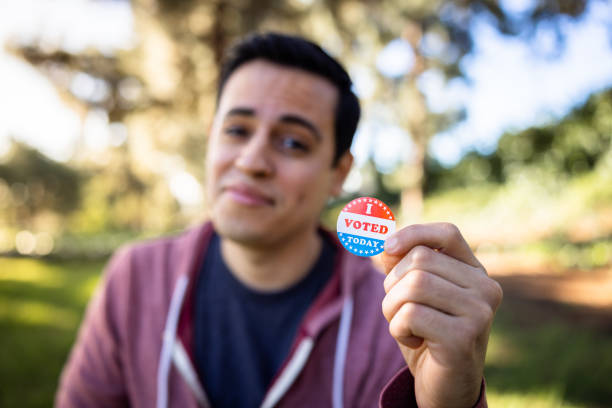 Young Mixed race hispanic man holding an I Voted Sticker