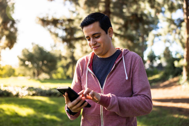 istock Young man texting on his smart phone 1457471413