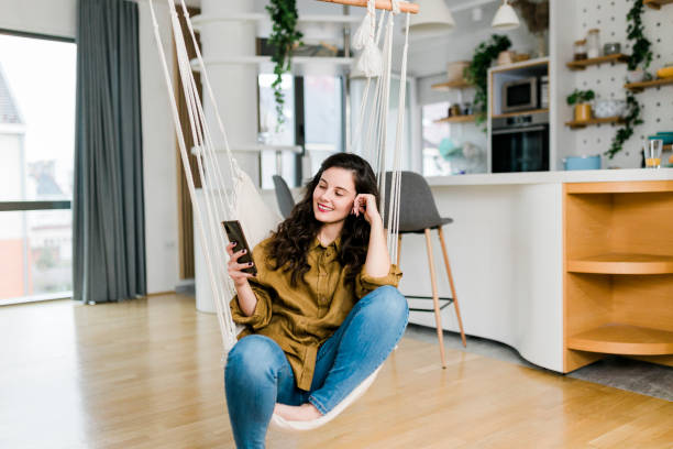 istock Woman using her phone and enjoying at home 1457474715