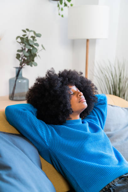 istock Cheerful black woman resting on sofa 1457476031