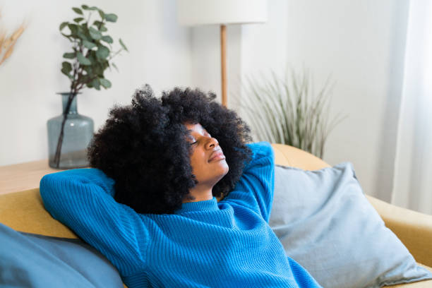 istock Cheerful black woman resting on sofa 1457476131