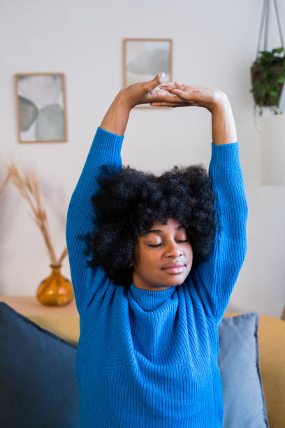 istock Young ethnic woman stretching at home 1457480252