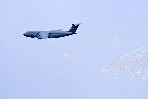 Dover, Delaware, USA - August 27, 2017: A U.S. Air Force C-5 Galaxy cargo airplane fires heat flares during a demonstration of its defensive capabilities.