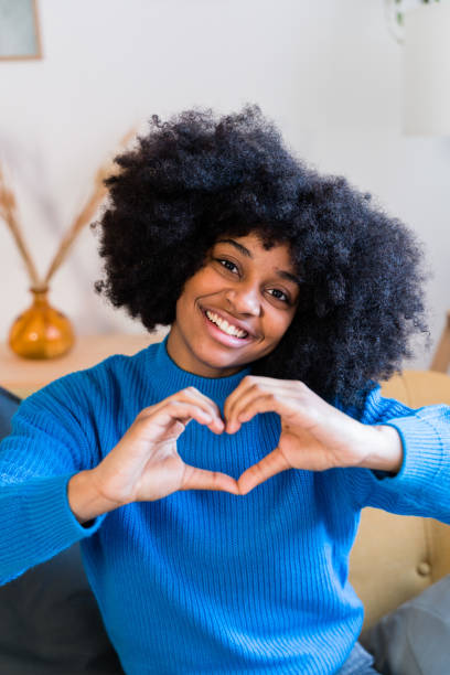 istock Cheerful black woman showing heart gesture 1457480769
