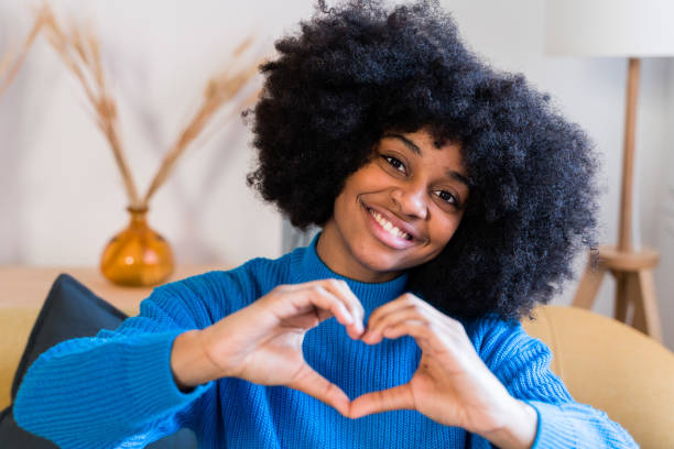 istock Cheerful black woman showing heart gesture 1457480900
