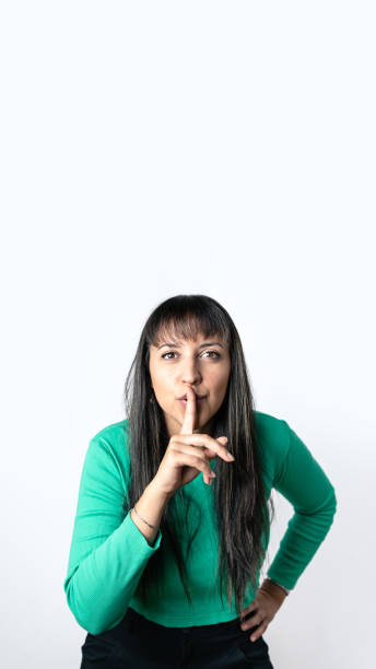 istock Brown hair woman with Hispanic features making silence gesture with her finger on lips over isolated white background 1457483734