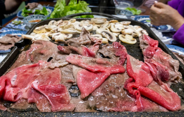 dünn geschnittene rindfleischstücke und champignons beim frittieren - meat emaciated beef barbecue stock-fotos und bilder