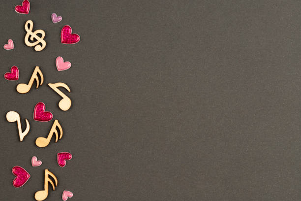 Musical wooden notes with hearts, top view.