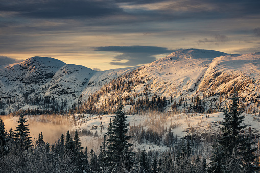 Panorama of a snowy mountain at sunrise in Norway