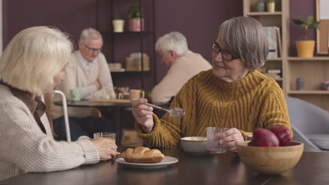 Old Ladies Chatting during Breakfast at Nursing Home