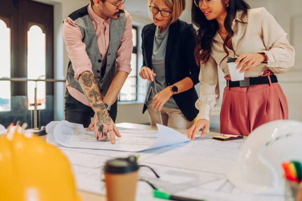 istock Multiracial team of architects having a meeting while using blueprints 1457486990