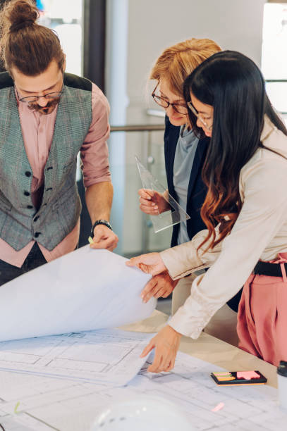 istock Multiracial team of architects having a meeting while using blueprints 1457486992