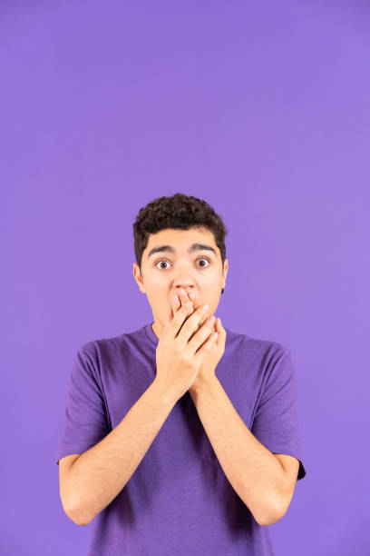 istock Surprised teenager boy hands on mouth 1457488651
