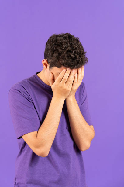 istock Sad teenager boy covering face 1457488662