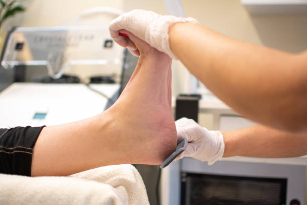 limpie el talón de pedicurista frotando el talón con un rallador especial en el tratamiento de pedicura en un salón de belleza. - scrub brush fotografías e imágenes de stock