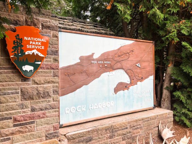 Large Wooden Map greets visitors at Isle Royale National Park in the Upper Peninsula of Michigan August 23, 2022, Isle Royale National Park, Michigan, USA, August 23, 2022, Isle Royale National Park, Michigan, USA, August 23, 2022, Isle Royale National Park, Michigan, USA, large wooden sign greets visitors upon arriving at  Rock Harbor within Isle Royale National Park. Sign indicates "You are Here" and illustrates the various trails on the island that is a National Park. Located in the Upper Peninsula of Michigan on Lake Superior. upper peninsula michigan map stock pictures, royalty-free photos & images