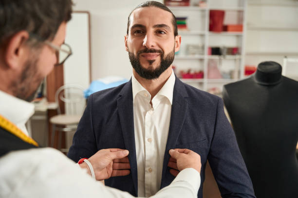 istock Experienced couturier trying on suit on young man 1457491081