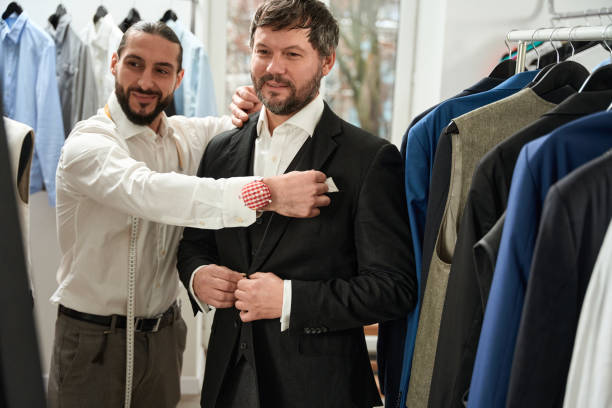 istock Contented tailor trying on item of clothing on his client 1457491702