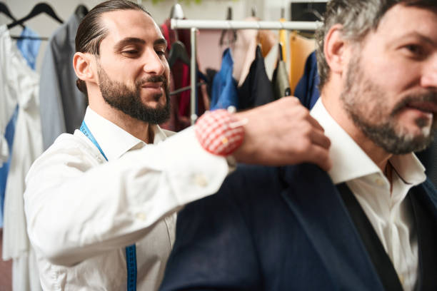 istock Pleased clothier checking fit of jacket on customer 1457491815