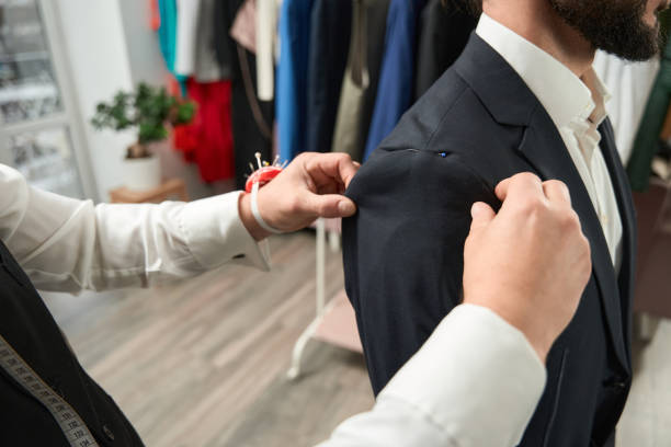 istock Experienced clothier altering suit jacket of client 1457491882