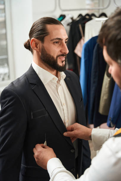istock Clothier making markings on garment of smiling customer 1457491889