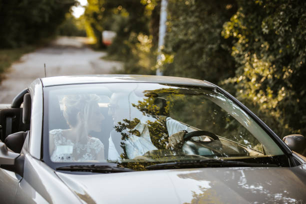 istock Just married young couple in convertible car 1457493791