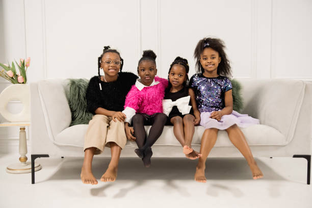 Portrait of black little girls sitting on a couch. stock photo