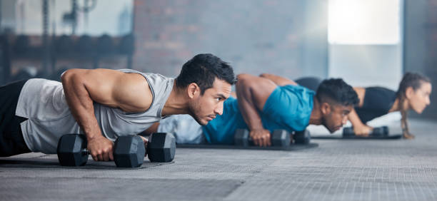 homens, mulheres e halteres no treino de ginásio, treino e exercício de fitness para o bem-estar da saúde, bíceps fortes ou músculos abdominais. personal trainer, treinador ou amigos da classe de levantamento de peso com objetivos de motivação - men exercising equipment relaxation exercise - fotografias e filmes do acervo