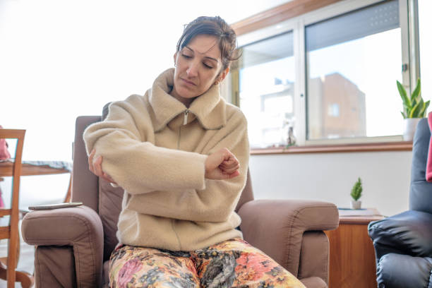 istock Woman sitting on sofa with elbow pain 1457498996