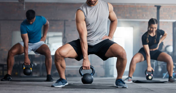istock Fitness, weightlifting and kettlebell class for arm workout, exercise or training together at the gym. Active people in sports exercising with kettle weights for healthy cardio endurance or wellness 1457500907
