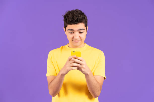 istock Front view of hispanic teenager boy using phone 1457505216