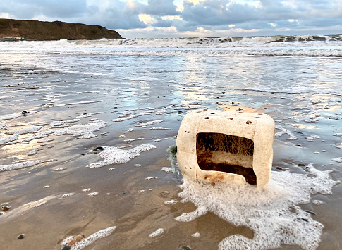 Plastic box used for fishing (lobster pot) washed up on the beach - contamination of the environment and unsightly pollution endangering fish and mammals