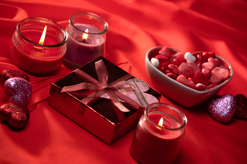 Valentines Day Chocolate Truffles Gift and Lighting Decorations on Silk Red Background