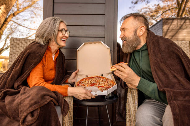istock Couple having pizza for lunch and looking xontented 1457507550
