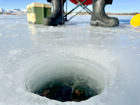 Ice fishing view of of the hole in the ice.