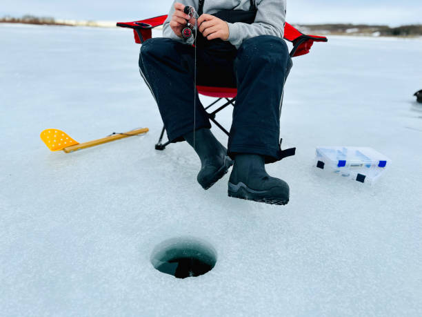 jeune homme pêche blanche - ice fishing photos et images de collection