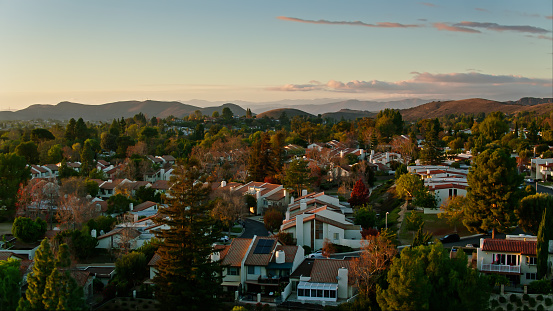 An image of a Thousand Oaks, CA townhouse complex at sunset. The complex and trees are covered in soft golden light.