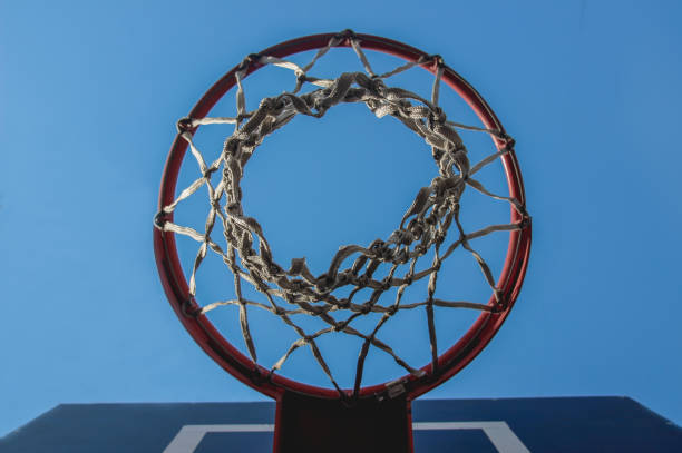 istock Basketball hoop with a grid on a blue sky background with a copy space background. Bottom view. Sports team game basketball, streetball. 1457516103