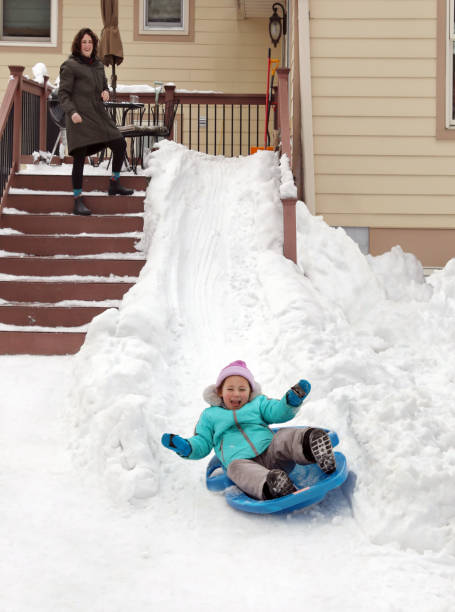 Two adorable little sisters enjoying sleight ride on snowy winter day