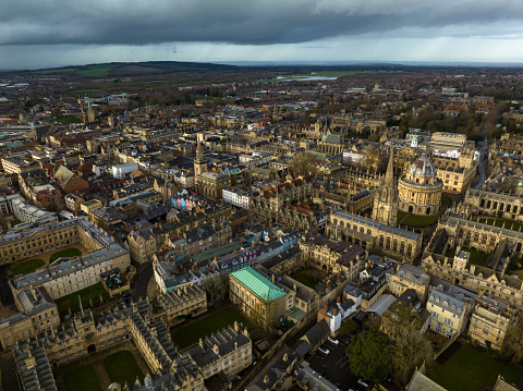 Aerial view of Oxford, England, flying over the city centre buildings and the colleges and libraries of the famous university on a cloudy day in winter.