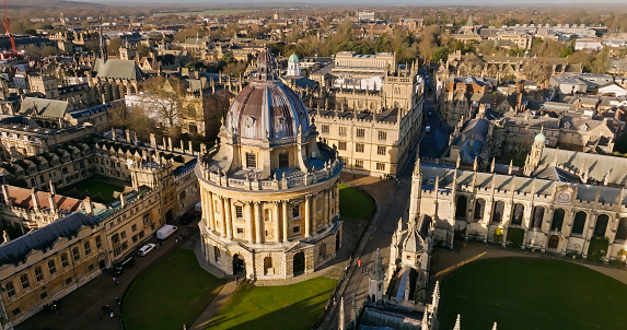 Aerial establishing shot of Oxford, England, flying over the city centre buildings and the colleges and libraries of the famous university.