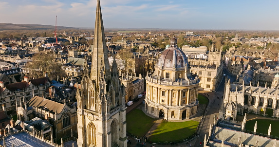 Aerial establishing shot of Oxford, England, flying over the city centre buildings and the colleges and libraries of the famous university.