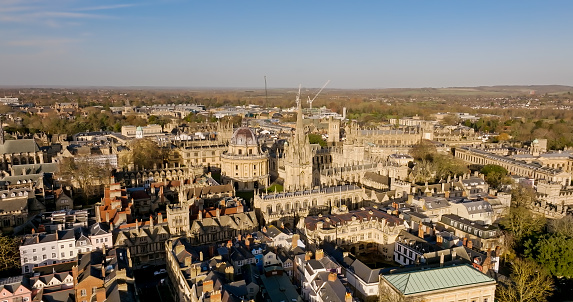 Aerial establishing shot of Oxford, England, flying over the city centre buildings and the colleges and libraries of the famous university.