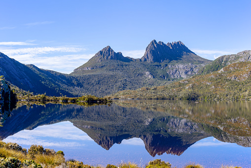 wide shot of cradle mountain reflected on dove lake on a calm summer morning at cradle mountain national park of tasmania, australia