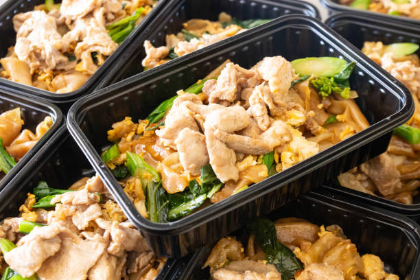 Thai food lunch boxs, Thai Stir-fried Rice Noodles with Black Soy Sauce and Pork (Pad See Ew) in take away plastic box. Thai street food, Delivery lunch box, Thai Stir-fried Rice Noodles with Black Soy Sauce and Pork (Pad See Ew) in take away plastic box. convenience food stock pictures, royalty-free photos & images