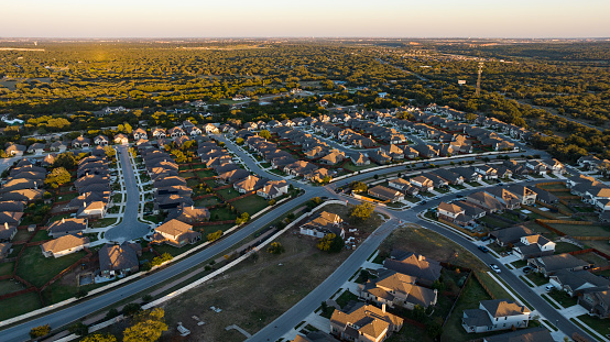 Aerial drone views at sunrise of a brand new suburb neighborhood in Georgetown Texas new suburbs new houses and homes. Endless new homes as Texas housing market expands across central texas