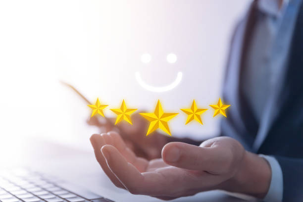 istock Customer's hands show five stars and smiley faces, the best feedback and responses from the product user experience. 1457536441