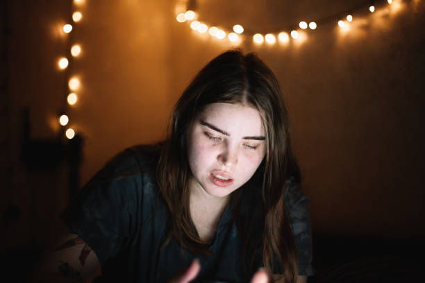 istock Young woman using smart phone and laptop computer at home at night 1457538415